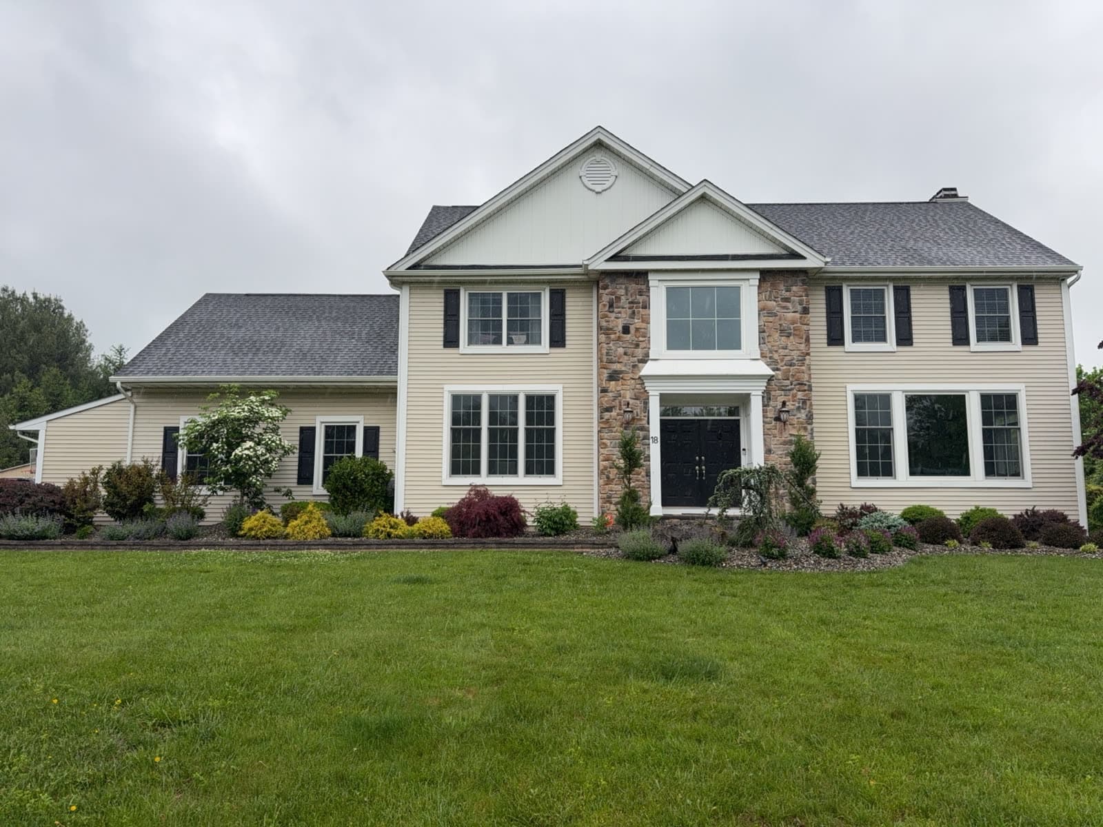 Two-story New Jersey colonial with dated tan vinyl siding before Revive renovation